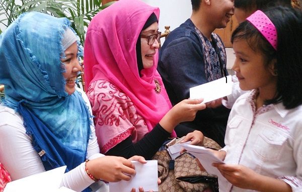 Anak mendapatkan uang tempel (angpao) saat Lebaran