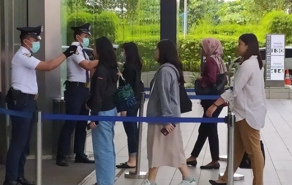 Petugas memeriksa dengan alat thermo scanner di sejumlah pintu masuk perkantoran yang ada di Sudirman Central Business District atau SCBD di Jakarta Selatan, Rabu, 11 Maret 2020