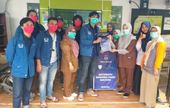 Mahasiswa Telkom University menyerahkan bantuan alat cuci tangan otomatis. (kalderanews.com/Dok.Telkom University)