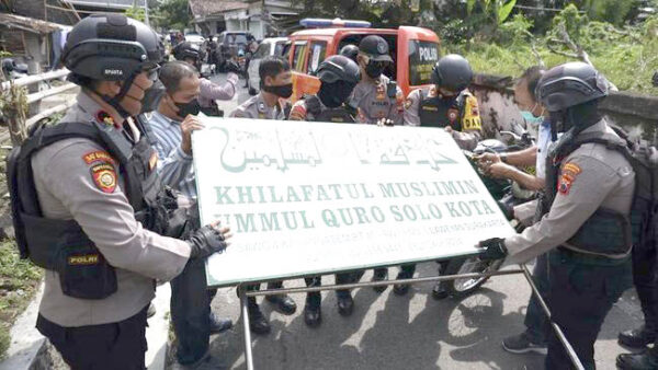 Polisi menurunkan papan bertuliskan Khilafatul Muslimin dari kantor cabang kelompok tersebut di Solo, Jawa Tengah. (AntaraFoto)