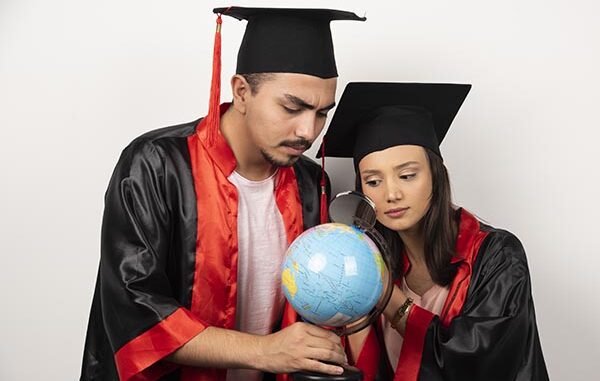 Dua orang lulusan sedang mengamati globe atau bola dunia. (Ist.)